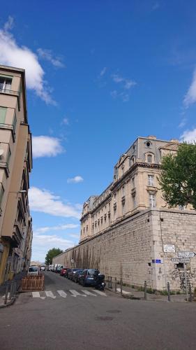 un grand bâtiment en briques avec des voitures garées dans une rue dans l'établissement St Charles / La Friche, à Marseille