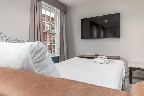 a hotel room with a bed and a television at Mercure Salisbury White Hart Hotel & Apartments in Salisbury
