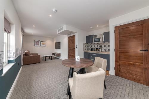 a kitchen and living room with a table and chairs at Mercure Salisbury White Hart Hotel & Apartments in Salisbury