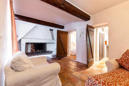un salon avec un canapé blanc et une cheminée dans l'établissement #47 17th Century House Pool, Parking, Sauna, Pétanque, BBQ, à Chateauneuf Villevieille