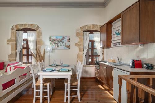 a kitchen with a table and chairs in a room at Arhontiko Arhanes Suites in Archanes
