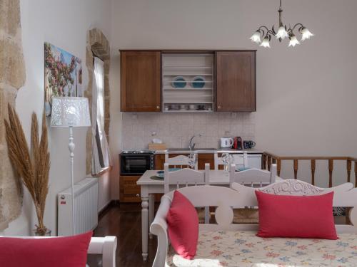 a kitchen and living room with red pillows on a table at Arhontiko Arhanes Suites in Archanes
