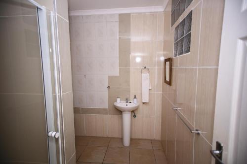 un baño con lavabo y ducha en Twenty 4 Hr Self-Catering Accomodation, en Mthatha