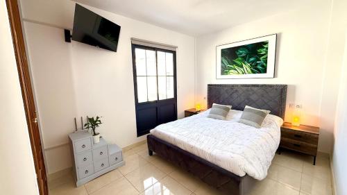 een slaapkamer met een bed en een flatscreen-tv bij Casa Lomas in Playa Blanca
