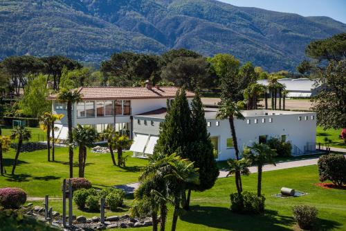 an aerial view of a white building with palm trees at Villa Favorita - Parkhotel Delta in Ascona