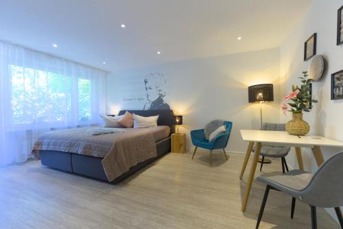 a bedroom with a bed and a table and chairs at Boutique Apartments am Stadtgarten in Freiburg im Breisgau