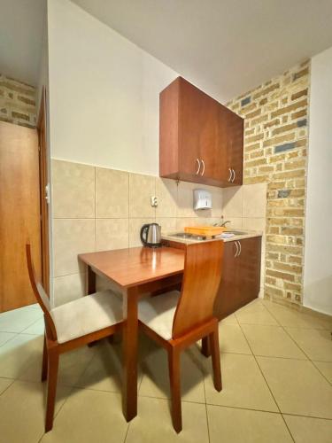 a small kitchen with a wooden table and chairs at Contessa Apartments in Budva