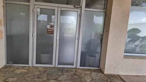 une paire de portes vitrées avec un panneau dessus dans l'établissement TERRA BELLA 2, à Grosseto-Prugna