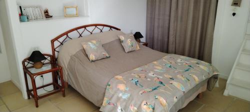 a bedroom with a bed with a comforter with birds on it at Le Clos Beldane in Le Tâtre