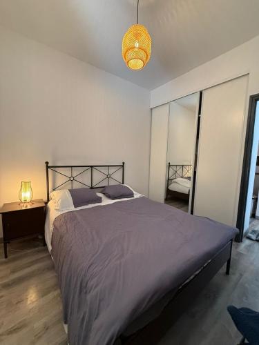une chambre avec un grand lit et une lampe dans l'établissement Appartement au cœur du Vieil Antibes, à Antibes