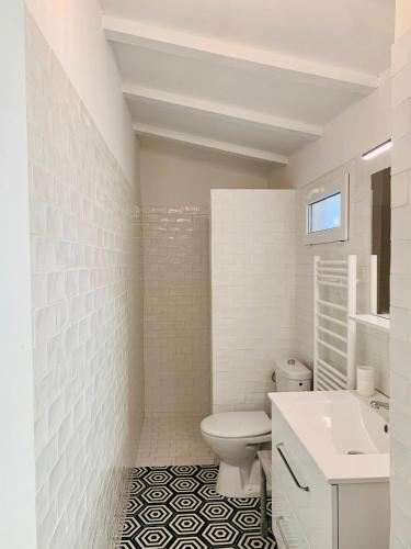 une salle de bain blanche avec des toilettes et un lavabo dans l'établissement Superb sea view villa with pool and big garden, à Pietrosella