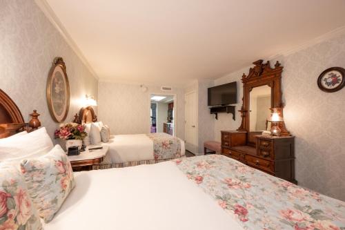 a hotel room with two beds and a television at Boardwalk Plaza Hotel in Rehoboth Beach