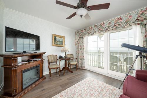 a living room with a fireplace and a television at Boardwalk Plaza Hotel in Rehoboth Beach