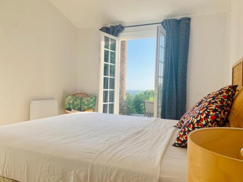 une chambre avec un grand lit blanc et une fenêtre dans l'établissement Superb sea view villa with pool and big garden, à Pietrosella