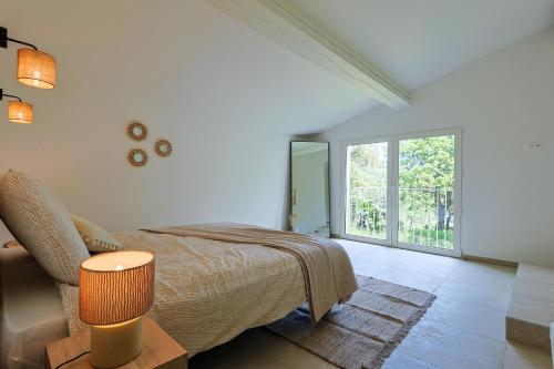 une chambre avec un lit et une grande fenêtre dans l'établissement Villa les prés, au Plan-de-la-Tour