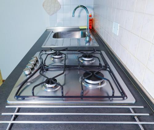 a stove top oven with a sink in a kitchen at Residence Villa Azzurra in Rimini