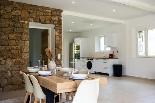 une cuisine et une salle à manger avec une table et des chaises en bois dans l'établissement Villa les prés, au Plan-de-la-Tour