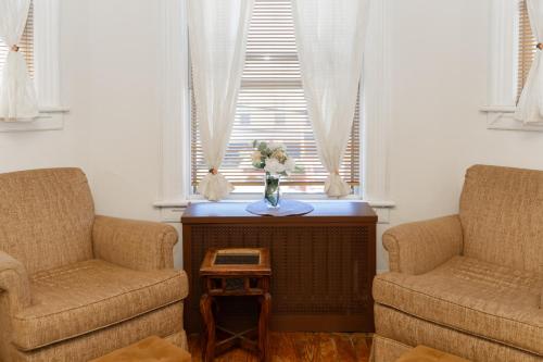 a living room with two chairs and a vase of flowers at 3 Bedroom Gem! King, Full & Twin Beds, Sauna with Free Parking plus more in Jersey City