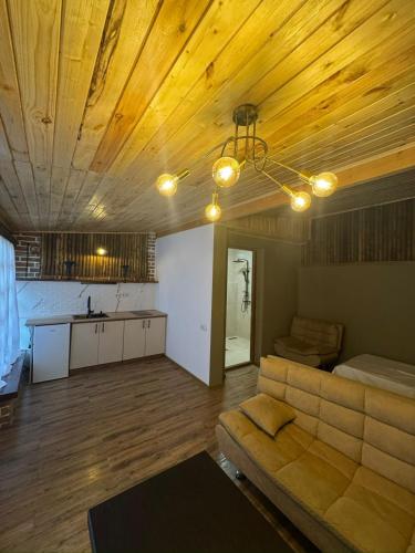 a living room with a couch and a kitchen at Safari House Tbilisi Wine & Family Hotel in Tbilisi City