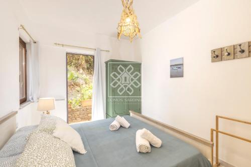 a bedroom with a bed with slippers on it at Wendy House in Stintino