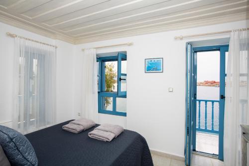 a bedroom with a bed and two windows at Villa Annouska in Halki