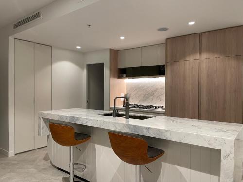 a kitchen with a large marble counter and wooden cabinets at Queen's Wharf - Hosted by Nick in Brisbane