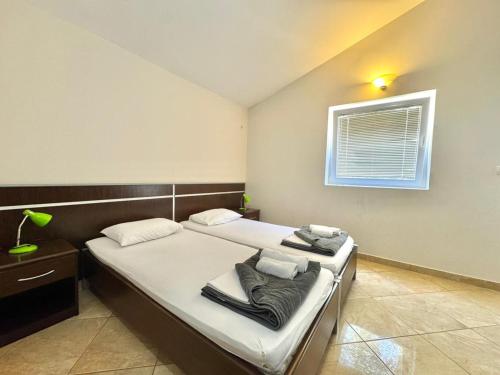 a bedroom with a bed with white sheets and a window at Contessa Apartments in Budva