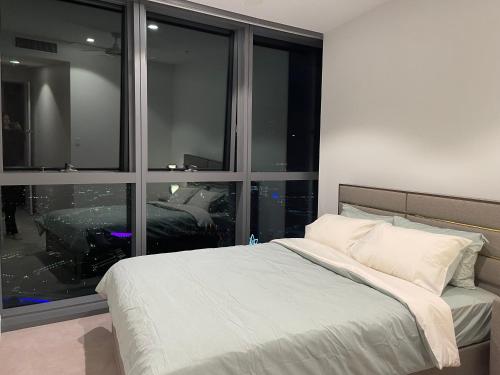 a bedroom with a bed and a large window at Queen's Wharf - Hosted by Nick in Brisbane