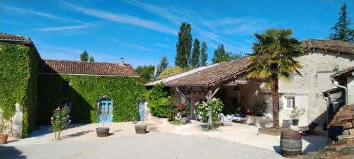 a house with a palm tree in a courtyard at Le Clos Beldane in Le Tâtre