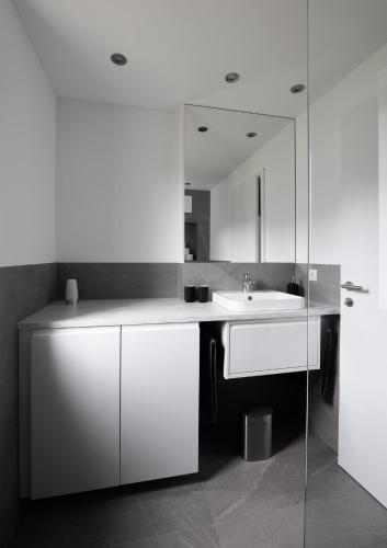 a white bathroom with a sink and a mirror at Ferienwohnung Simlhof in Inzing