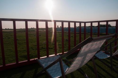 a couple of chairs on a balcony with the sun at Hihahut De Zonnepost in Oud-Ade