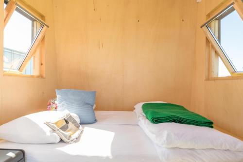 two beds in a small room with two windows at Hihahut De Zonnepost in Oud-Ade