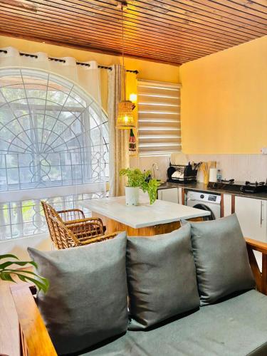 un soggiorno con un divano e un tavolo con una cucina di Minzi Homes a Dar es Salaam