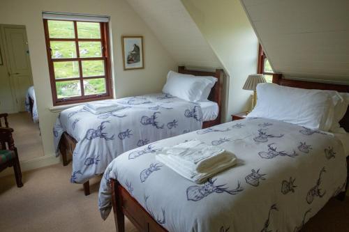 ein Schlafzimmer mit zwei Betten und einem Fenster in der Unterkunft Glen Dessary Estate - Fully Catered Bespoke Highland Lodge in Spean Bridge