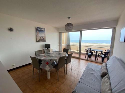 une salle à manger avec une table et une vue sur l'océan dans l'établissement Appartement 3 pièces avec parking, à 10m de la plage - 6 couchages - FR-1-229C-171, à Port-la-Nouvelle