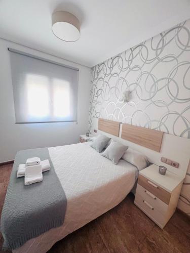 a bedroom with a large white bed with a wall at PENSION NAVAS in El Cabo de Gata