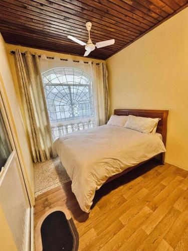una camera da letto con un letto grande e una finestra di Minzi Homes a Dar es Salaam