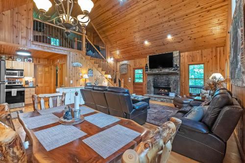 a living room with a dining room table and a fireplace at Mountain Getaway with Hot Tub & Game Room cabin in Cleveland
