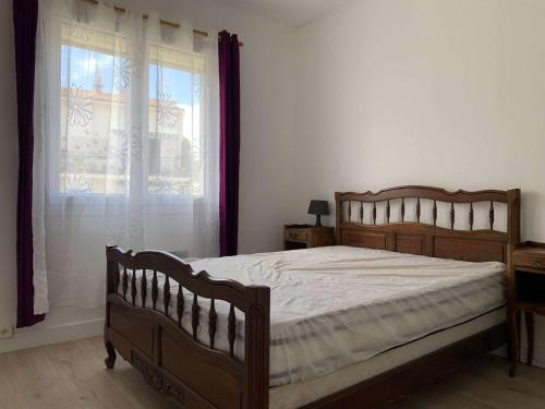 une chambre avec un lit en bois et une fenêtre dans l'établissement Appartement rénové 4-6 pers à 200m de la plage avec parking privé, centre de Saint Pierre - FR-1-229D-122, à Fleury