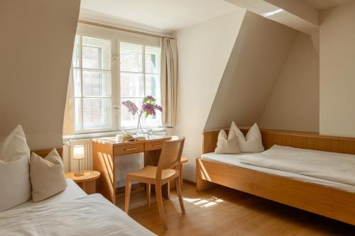 Camera con 2 letti, scrivania e finestra. di Klosterhotel Lehnin a Lehnin