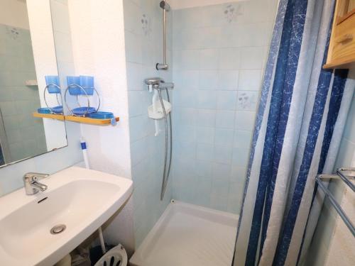 une salle de bain avec un lavabo et une douche dans l'établissement Studio Cabine avec terrasse ensoleillée, piscines, parking privé, à 500m de la plage - FR-1-307-133, au Grau-du-Roi