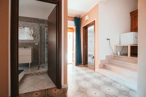 a bathroom with a walk in shower and a mirror at Villa Bella Salmagi - Surya Sardinia Holidays & Yoga in Capitana