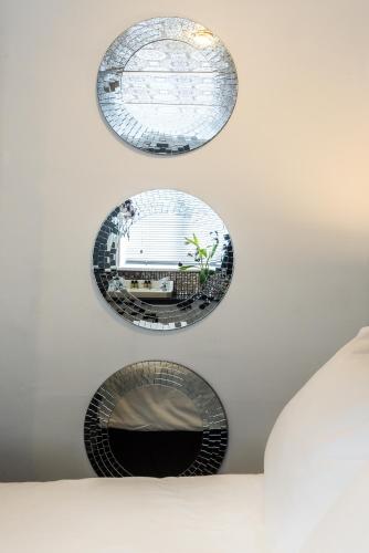 three circular mirrors hanging on a white wall at Paskins Town House in Brighton & Hove