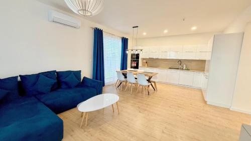 a living room with a blue couch and a table at Klimatizovaný Apartmánový dom s bazénom, 10B in Senec