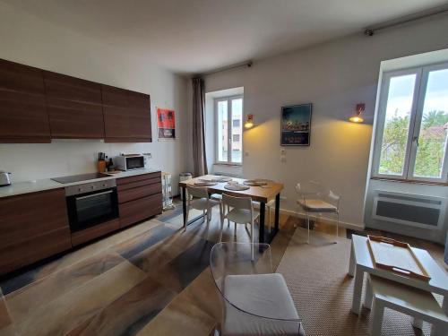 une cuisine avec une table et des chaises dans une pièce dans l'établissement Bienvenue à Sanary ! A deux pas du port, à Sanary-sur-Mer