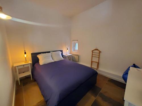- une chambre avec un lit doté de draps violets et d'oreillers blancs dans l'établissement Bienvenue à Sanary ! A deux pas du port, à Sanary-sur-Mer
