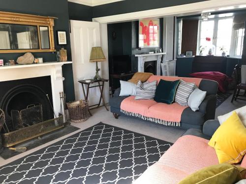 a living room with a couch and a fireplace at Boho Family Escape near Dunraven Bay with Sea Views in Southerndown