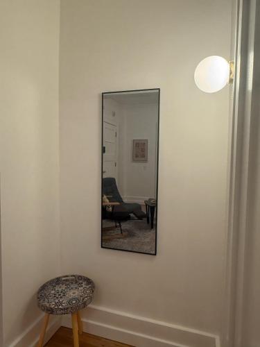 a mirror on a wall with a stool and a chair at Your Cozy-studiohighfallstvkitchenrochestdt in Rochester