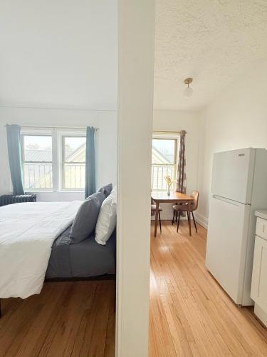 a bedroom with a bed and a table and a refrigerator at Your Cozy-studiohighfallstvkitchenrochestdt in Rochester
