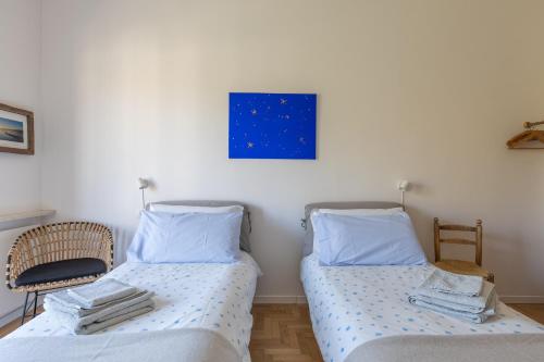 a bedroom with two beds and a blue painting on the wall at Blue Dream in Ispra
